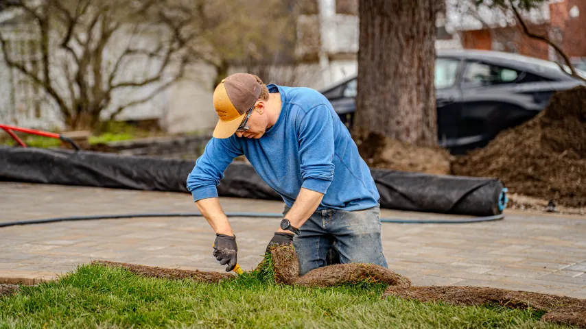 Bouwers crew member kneeling to install sod.