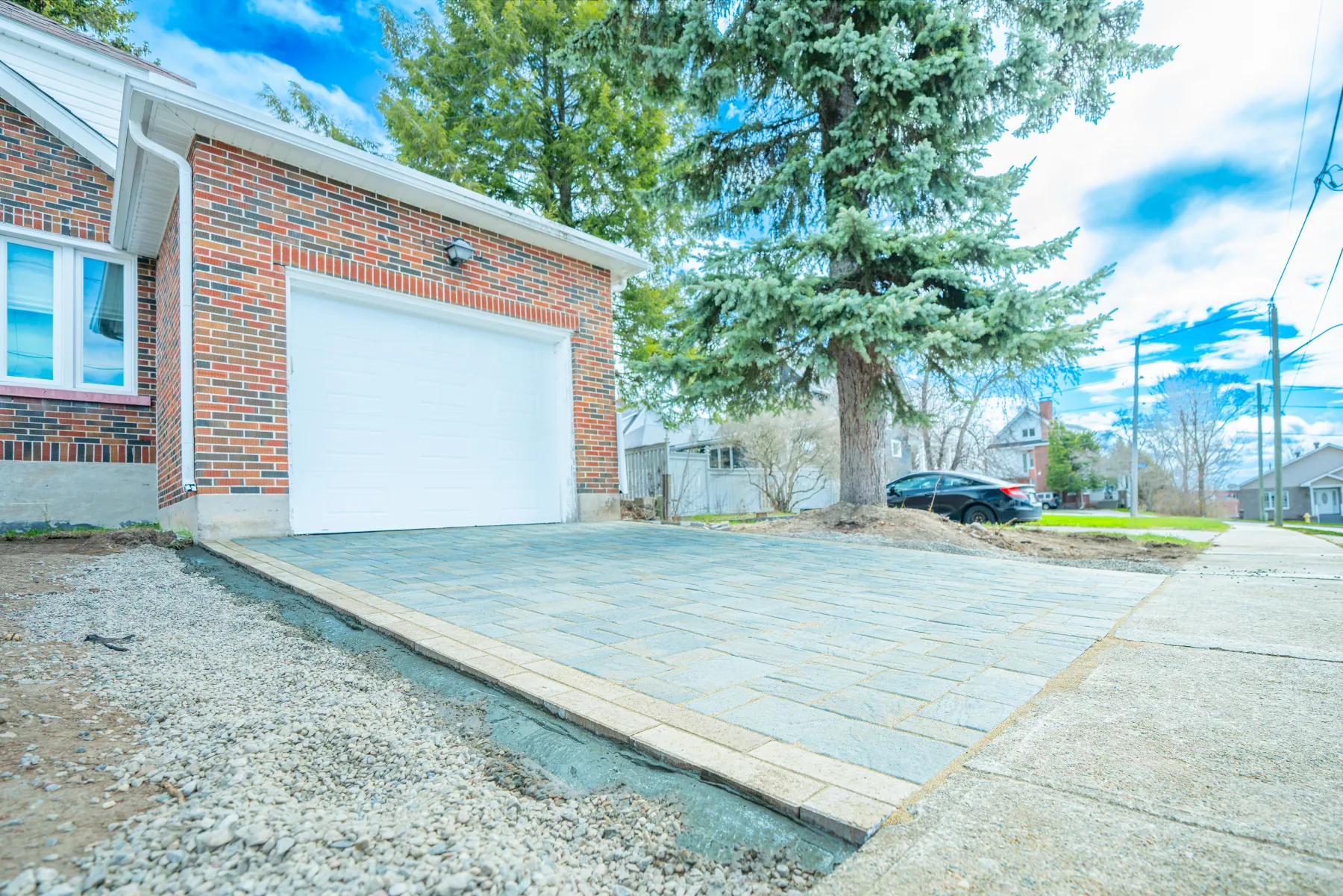 Side-angle view of the finished interlock driveway showing edge restraint and lawn transition.