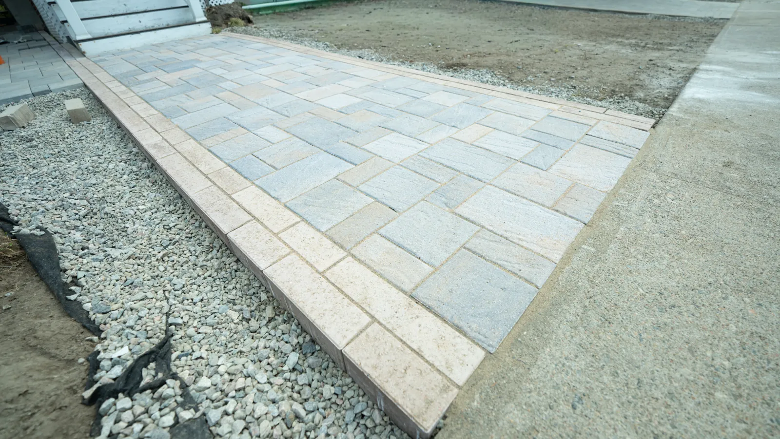 Hand-laid interlock paver detail with stone aggregate edge, North Bay, Ontario.