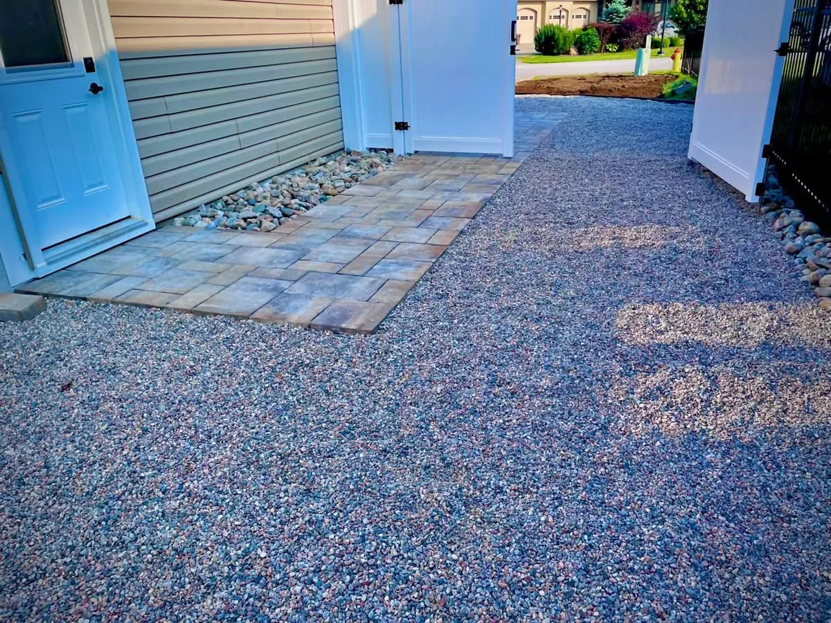 Paver landing transitioning to decorative aggregate driveway on a Bouwers Design Landscaping project, North Bay.