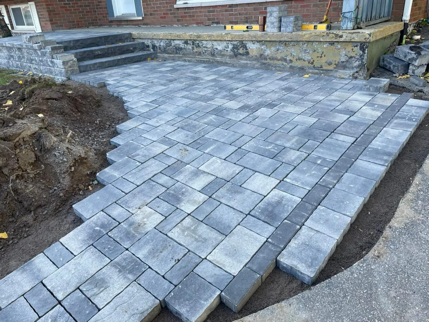 Permacon paver walkway in progress, running from driveway to porch on a North Bay home.
